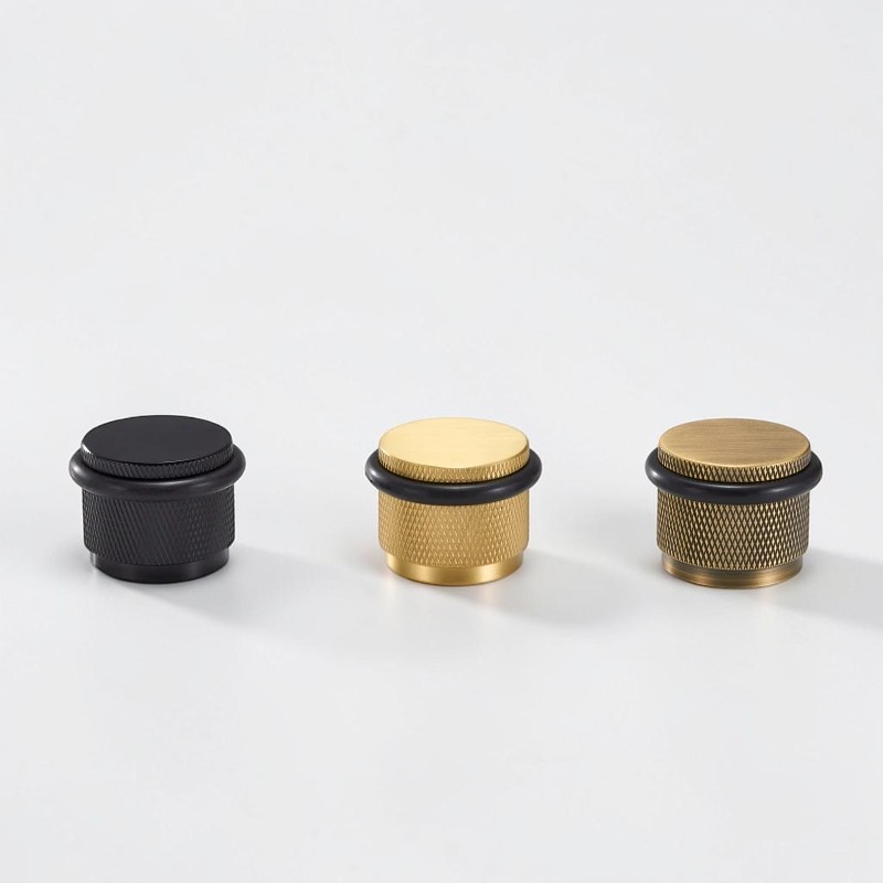 Black, brushed and aged brass knurled floor door stops with rubber bumper rings