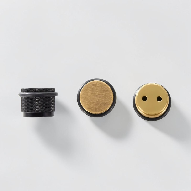 Side, top and underside views of knurled brass floor door stops showing the rubber ring and mounting base
