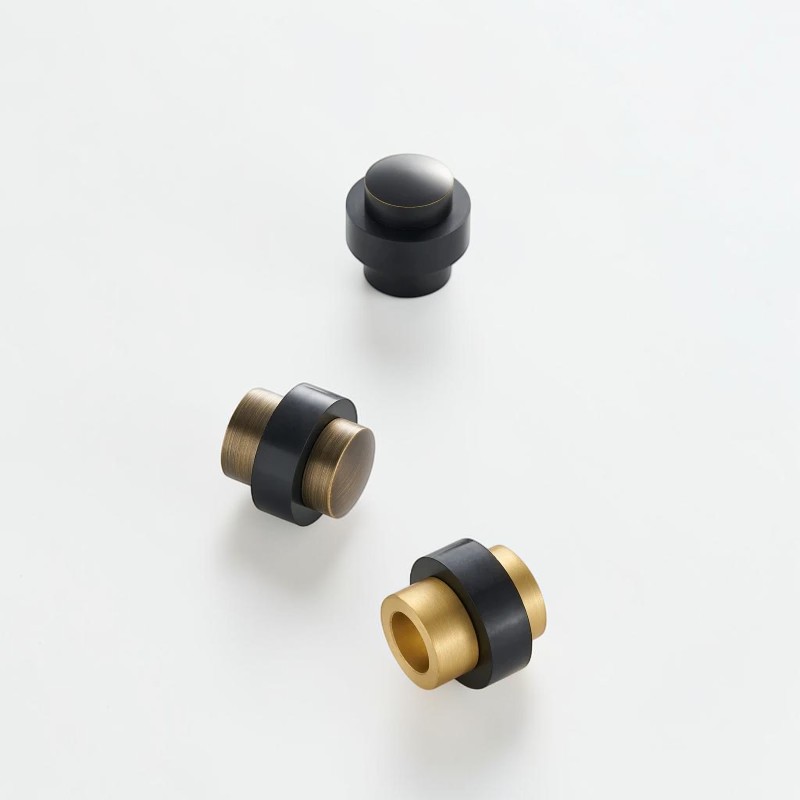Black, aged and brushed brass door stop bodies with projecting rubber bumpers