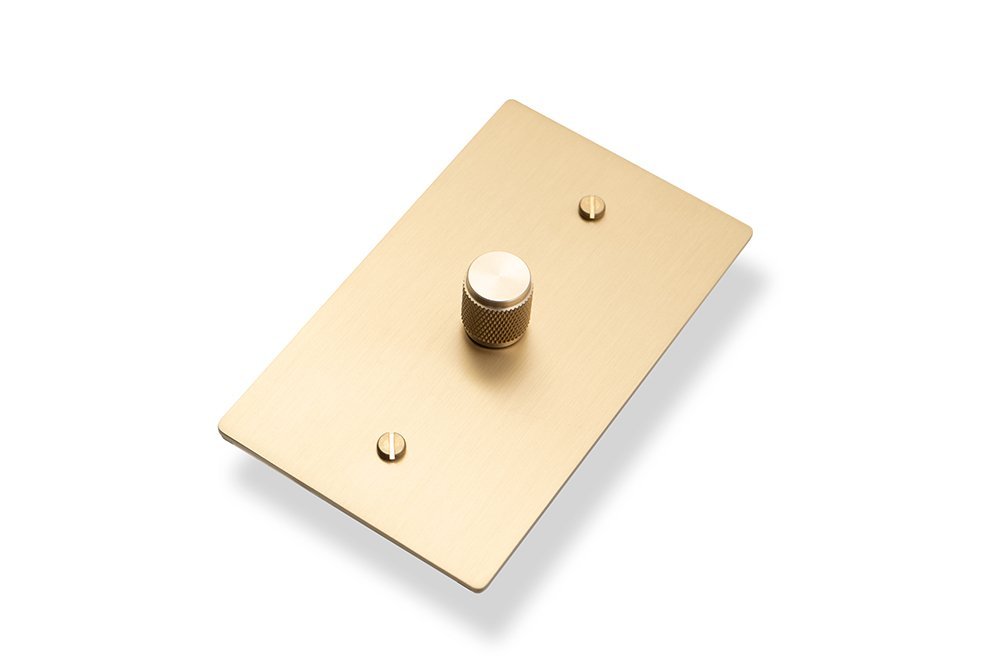 Brass single pole lighting dimmer photographed at an angle, showing its knurled rotary control.